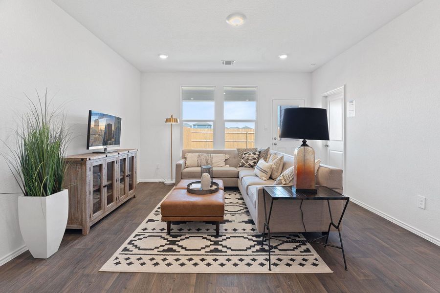 Living area featuring baseboards, dark wood-style flooring, and recessed lighting