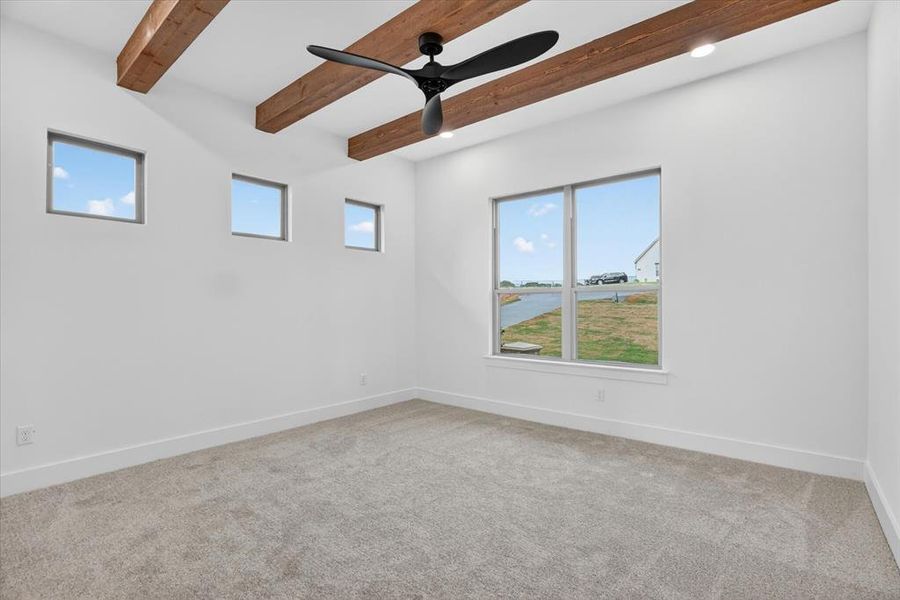 Spacious room featuring exposed wood ceiling beams, a ceiling fan, and recessed lighting