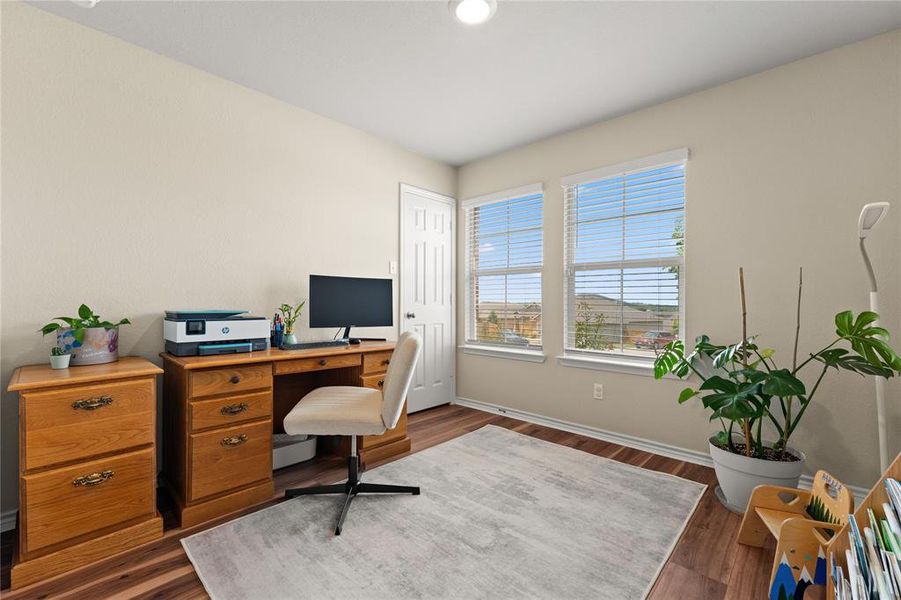 Office space featuring dark wood-style flooring and baseboards