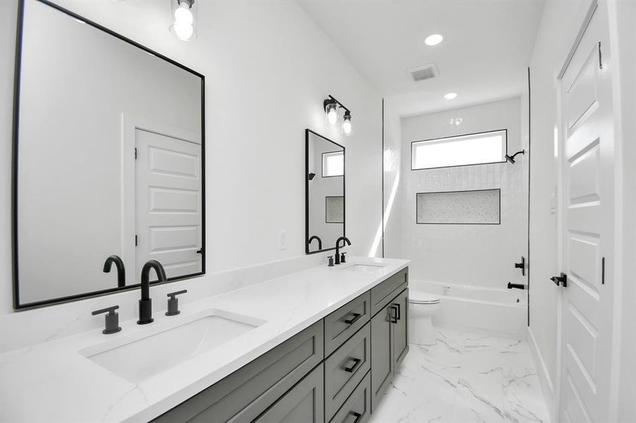 Full secondary bathroom featuring dual sinks and tub/shower combo.