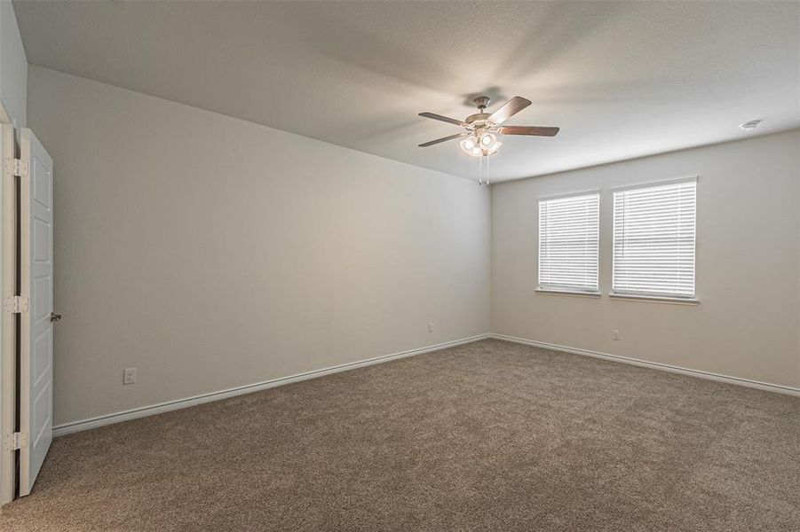 Carpeted empty room with ceiling fan