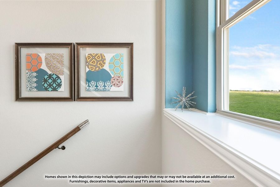 Stairway landing with two framed geometric art prints, wood handrail, and large window with outdoor view Stairway landing with two framed geometric art prints, wood handrail, and large window with outdoor view
