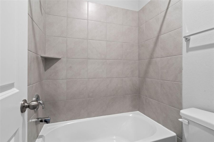 View of secondary bathroom tub/shower combination with tile surround. View of secondary bathroom tub/shower combination with tile surround.