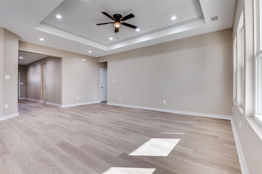 Unfurnished room featuring a tray ceiling, recessed lighting, and baseboards