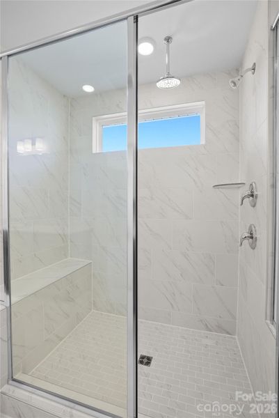 Owner's full tile shower has bench seat and dual shower heads