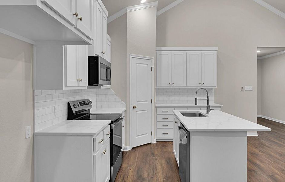 Kitchen with stainless steel appliances, ornamental molding, dark wood finished floors, a kitchen island with sink, and light stone countertops