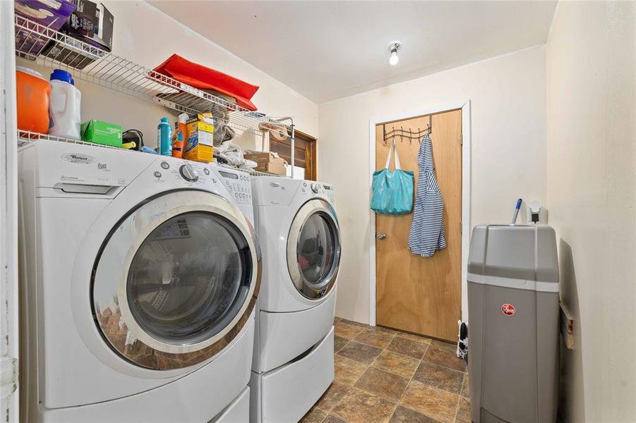 Washroom featuring stone finish flooring and washing machine and clothes dryer Washroom featuring stone finish flooring and washing machine and clothes dryer