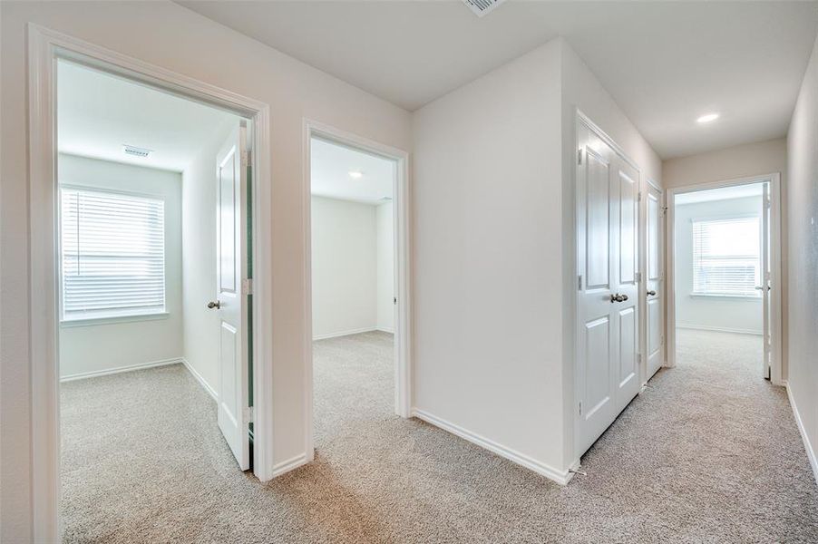 Hallway featuring light carpet