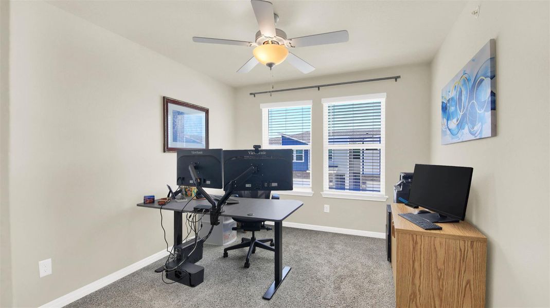 Spacious room featuring carpeting, light-toned wall paint, and a ceiling fan with integrated lighting