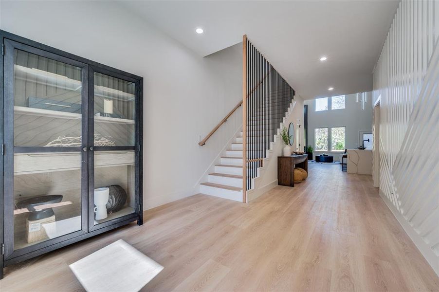 Foyer with a towering ceiling and light hardwood / wood-style flooring