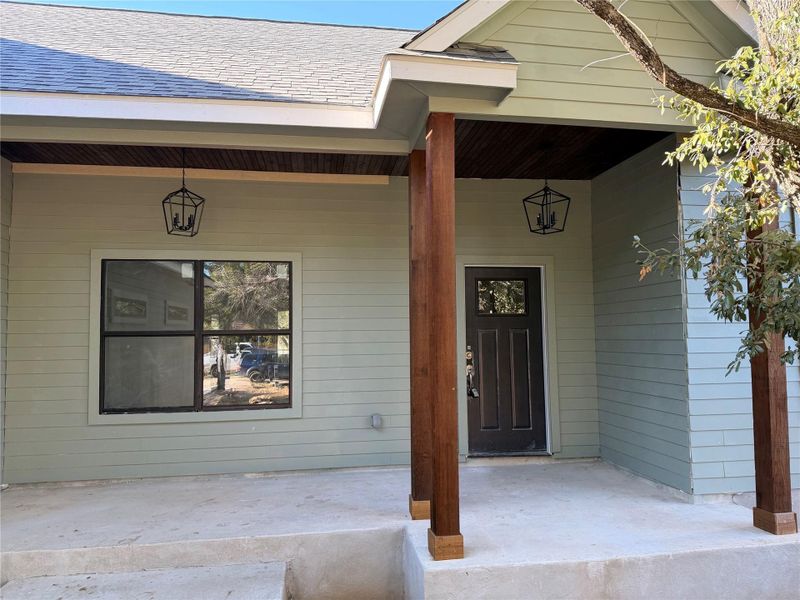 Doorway to property with a porch and roof with shingles Doorway to property with a porch and roof with shingles