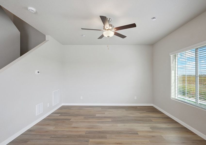 The family room is spacious with a ceiling fan and plank flooring.