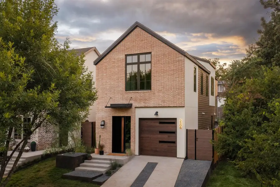 Clean lines and a modern brick facade create exceptional curb appeal under dramatic evening skies. Clean lines and a modern brick facade create exceptional curb appeal under dramatic evening skies.