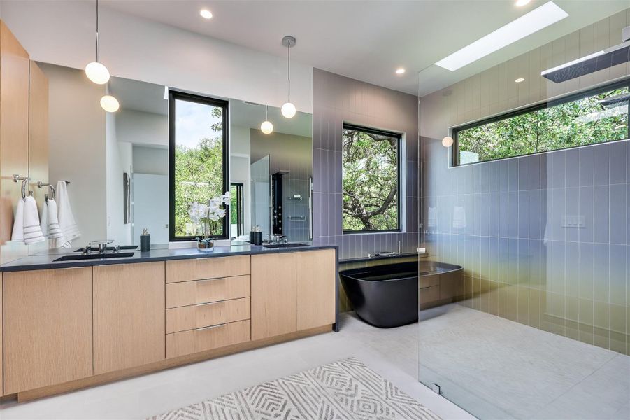Custom double vanities with a storage tower ensure everything has its place in this light-filled, spa-inspired space