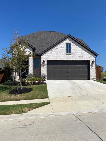 View of front of property with a front garage and a stained wood fence.