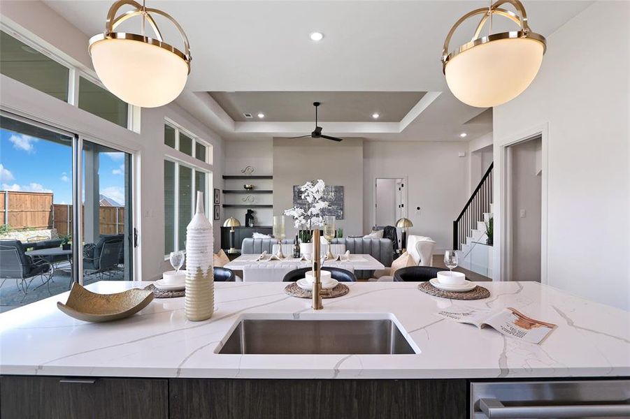 Kitchen island featuring a stainless steel undermount sink and a white countertop with gray veining