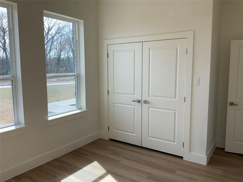 Unfurnished bedroom with wood finished floors and a closet Unfurnished bedroom with wood finished floors and a closet