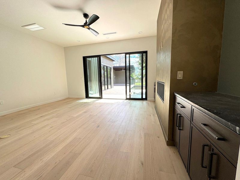 Unfurnished living room with visible vents, a ceiling fan, light wood-type flooring, and baseboards