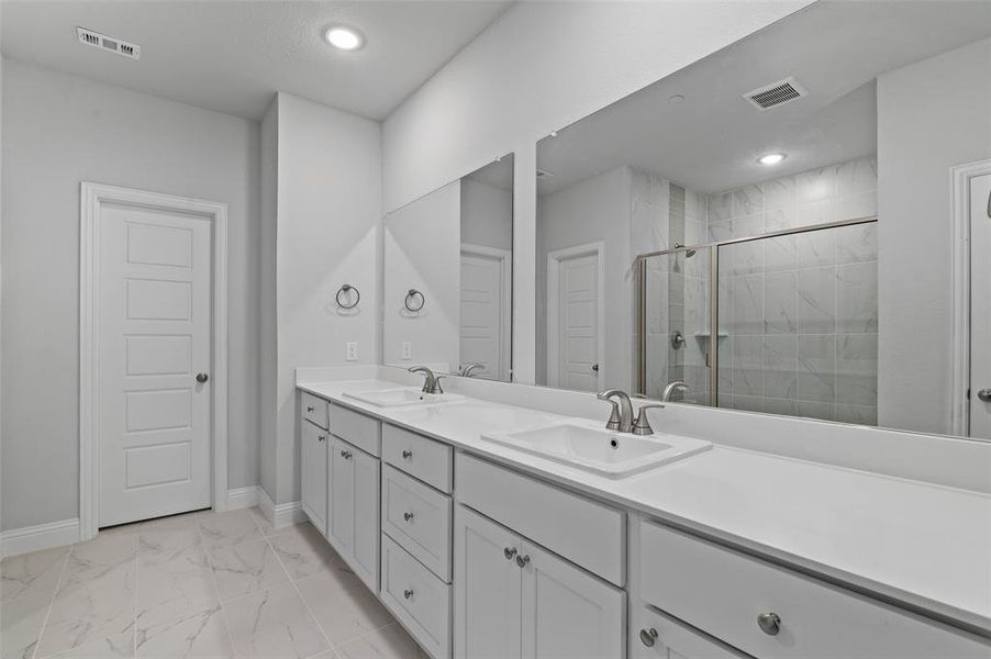 Bathroom featuring tile patterned floors, an enclosed shower, and dual vanity