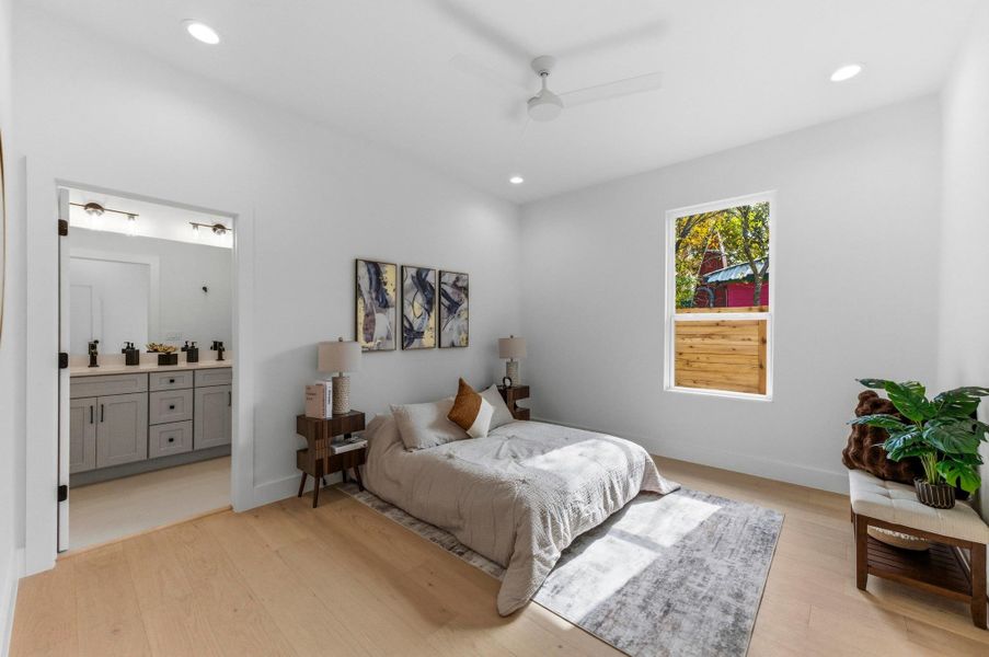 Bedroom with light wood-type flooring, ceiling fan, ensuite bath, and recessed lighting
