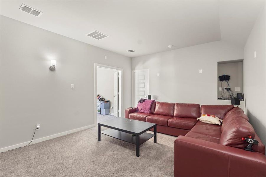 Living area featuring light carpet and vaulted ceiling Living area featuring light carpet and vaulted ceiling