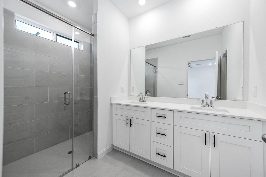 The en-suite bath featuring dual vanity sinks and a modern walk in shower. The en-suite bath featuring dual vanity sinks and a modern walk in shower.