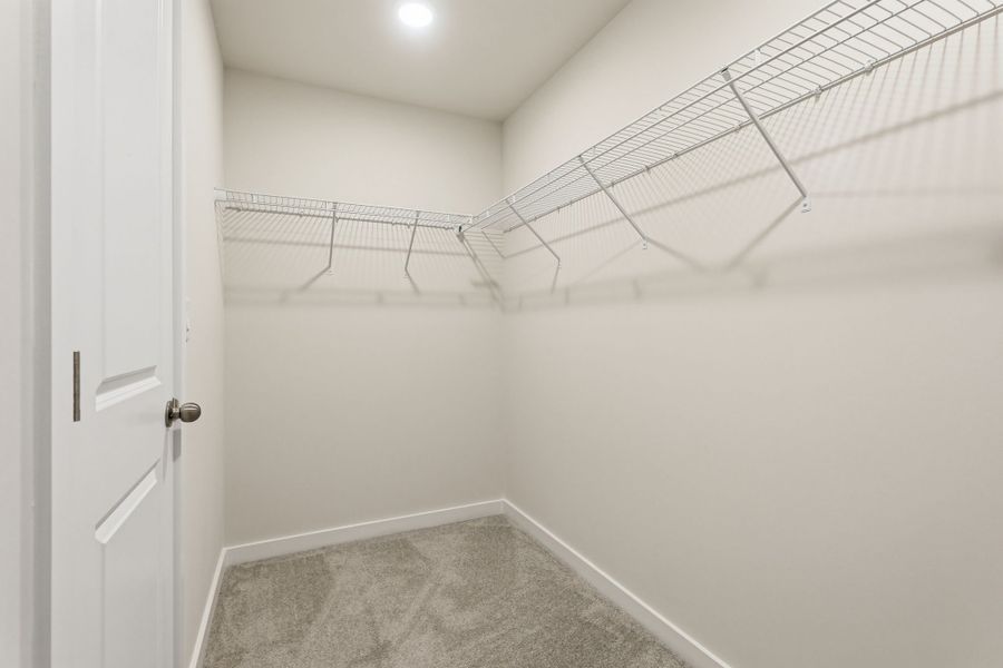 A white tiled room with a metal railing.