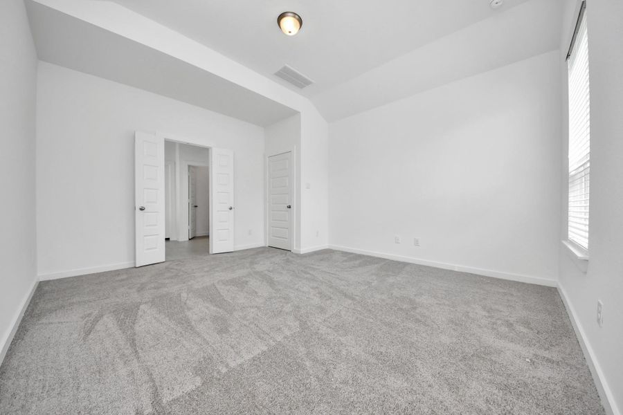 Come and unwind after a long day in this magnificent primary suite! This spacious room features plush carpet, warm paint, high ceilings and large windows with privacy blinds. Sample photo of completed home with similar floor plan. Actual colors and selections may vary.