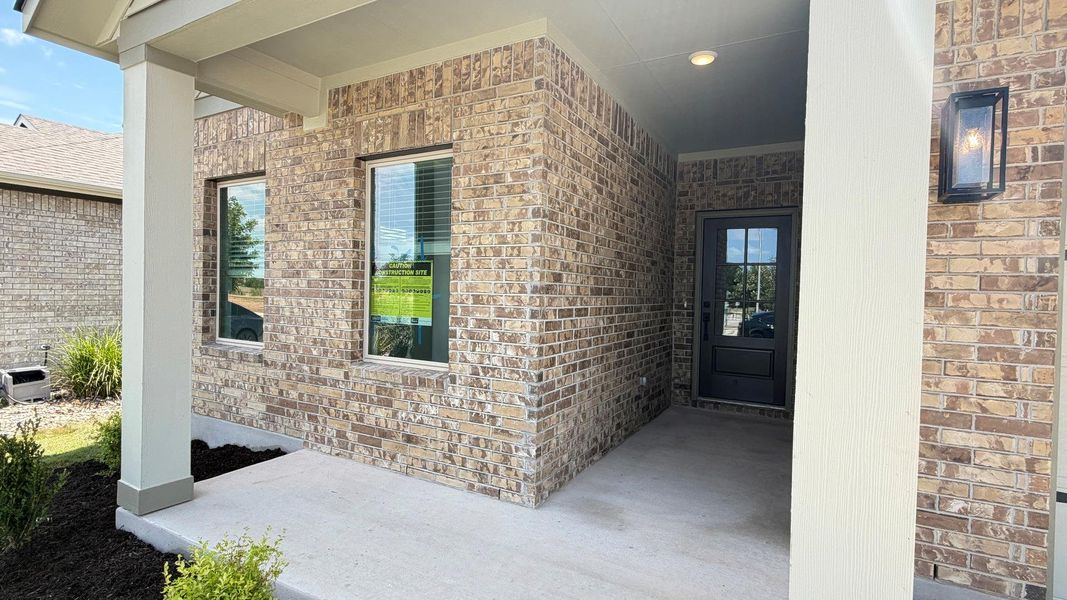 A welcoming front entry features classic brickwork and a covered porch, creating inviting curb appeal. A welcoming front entry features classic brickwork and a covered porch, creating inviting curb appeal.