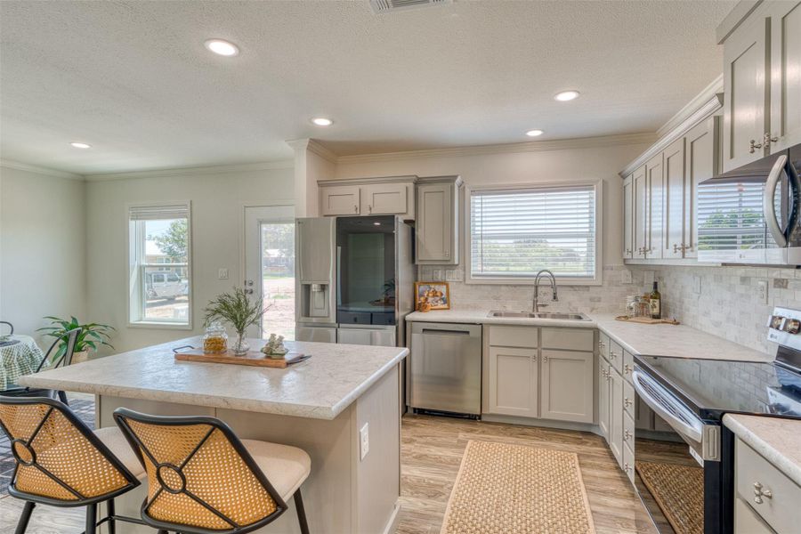 Culinary adventures await in this kitchen, featuring an inviting island, ample cabinetry, and stainless steel appliances. Culinary adventures await in this kitchen, featuring an inviting island, ample cabinetry, and stainless steel appliances.