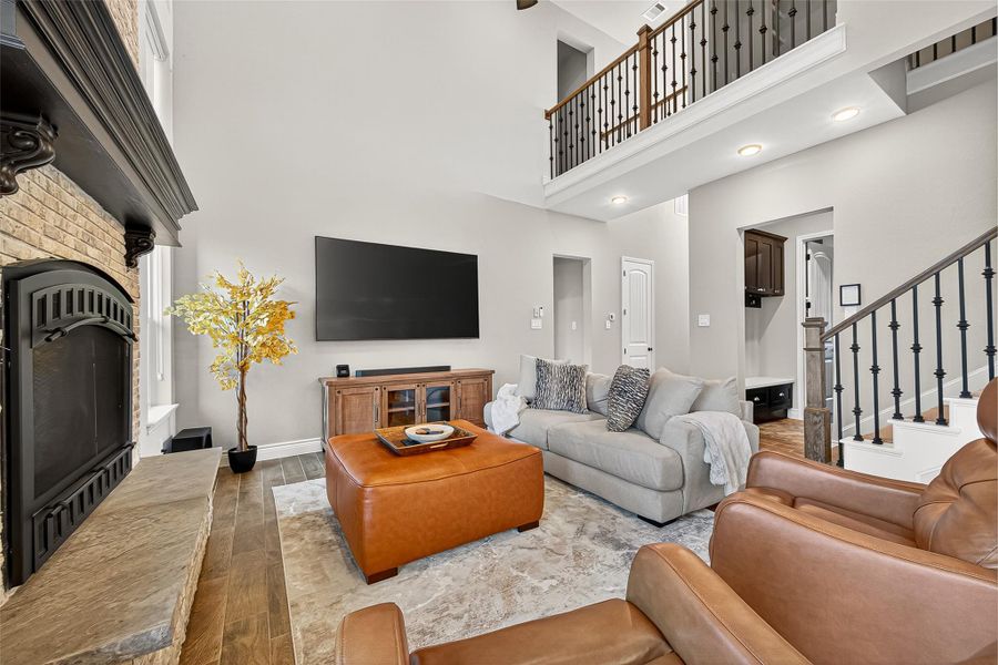 Two-story family room with soaring ceilings, elegant fireplace, and iron-spindle staircase offering a grand yet inviting feel. Two-story family room with soaring ceilings, elegant fireplace, and iron-spindle staircase offering a grand yet inviting feel.