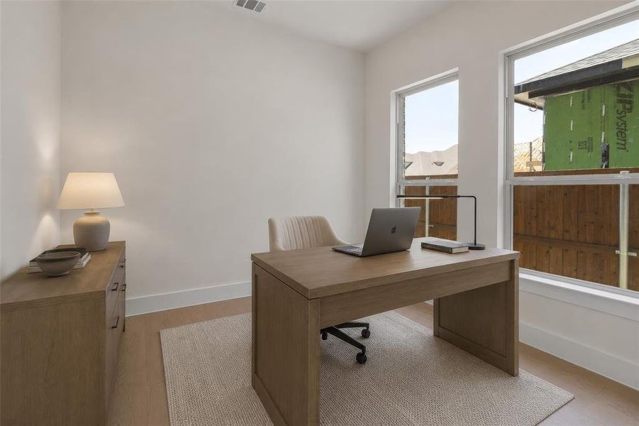 Bright interior space featuring light-toned wood-finish flooring and white baseboards