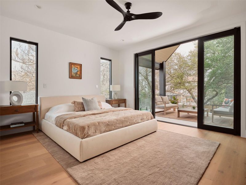 Bedroom featuring access to exterior, light wood-style flooring, and ceiling fan