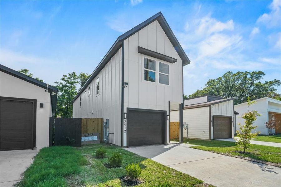 View of front of house with board and batten siding, a garage, and driveway
