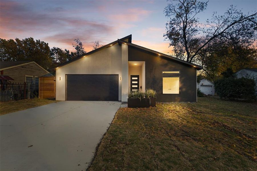 Contemporary home with stucco siding, concrete driveway, and an attached garage