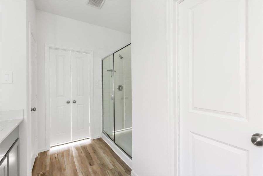 Primary bath view with over sized shower, linen closed and double doors to the bedroom. Primary bath view with over sized shower, linen closed and double doors to the bedroom.