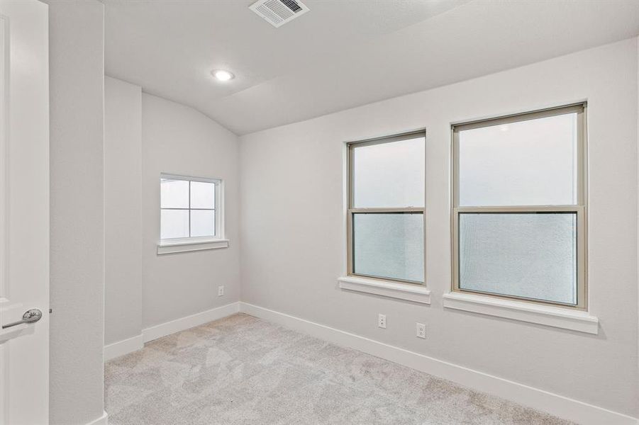 Carpeted spare room with lofted ceiling