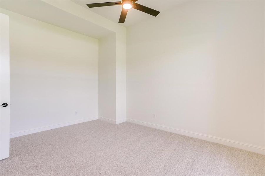 Spare room featuring ceiling fan and carpet flooring