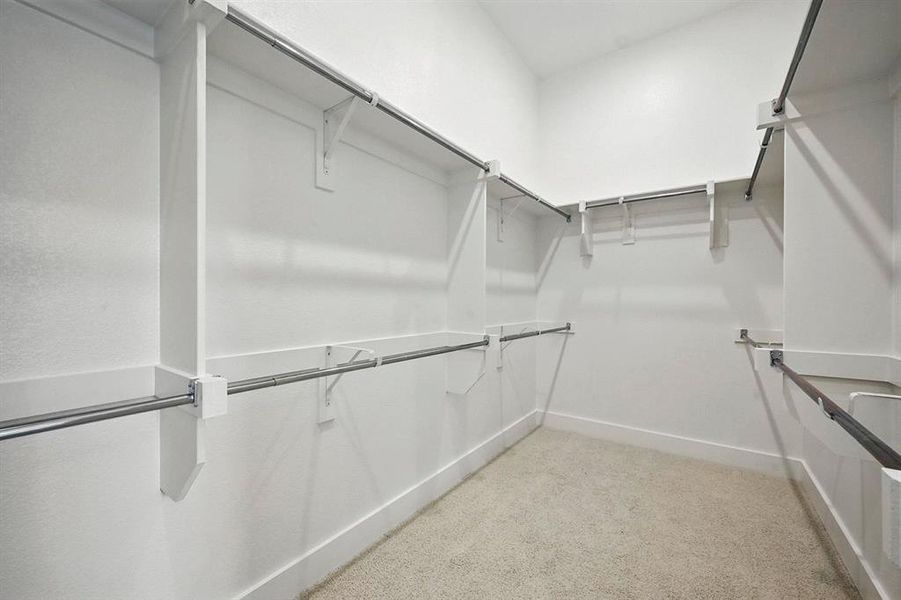 Walk in closet with light carpet