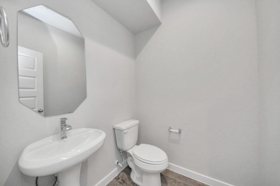 This half bathroom features a stylish pedestal sink, modern hardware, and bright recessed lighting, creating a sleek and inviting space. This half bathroom features a stylish pedestal sink, modern hardware, and bright recessed lighting, creating a sleek and inviting space.