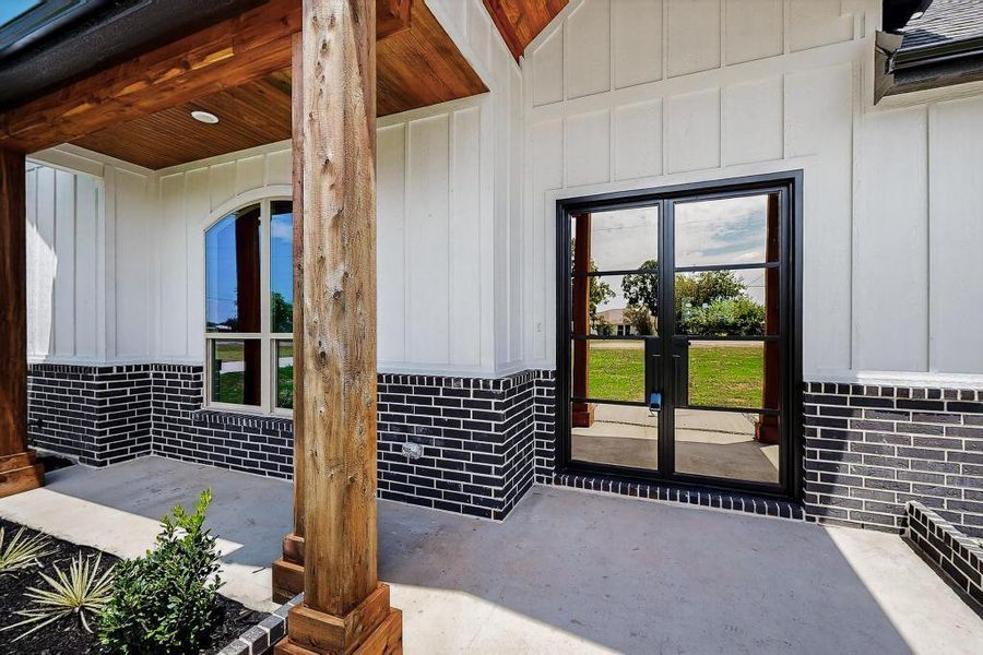 View of exterior entry with french doors and board and batten siding