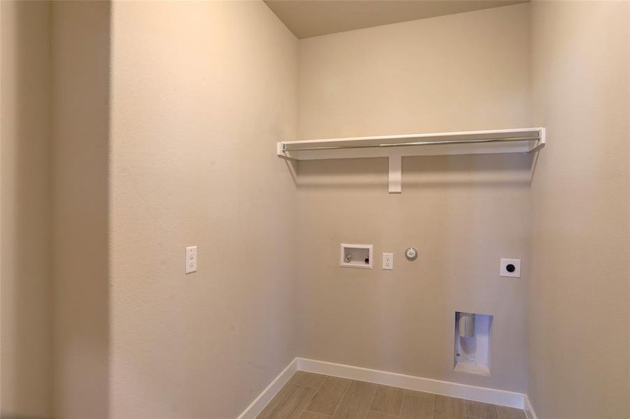 Laundry area with hookup for a gas dryer, wood finish floors, hookup for an electric dryer, and washer hookup Laundry area with hookup for a gas dryer, wood finish floors, hookup for an electric dryer, and washer hookup