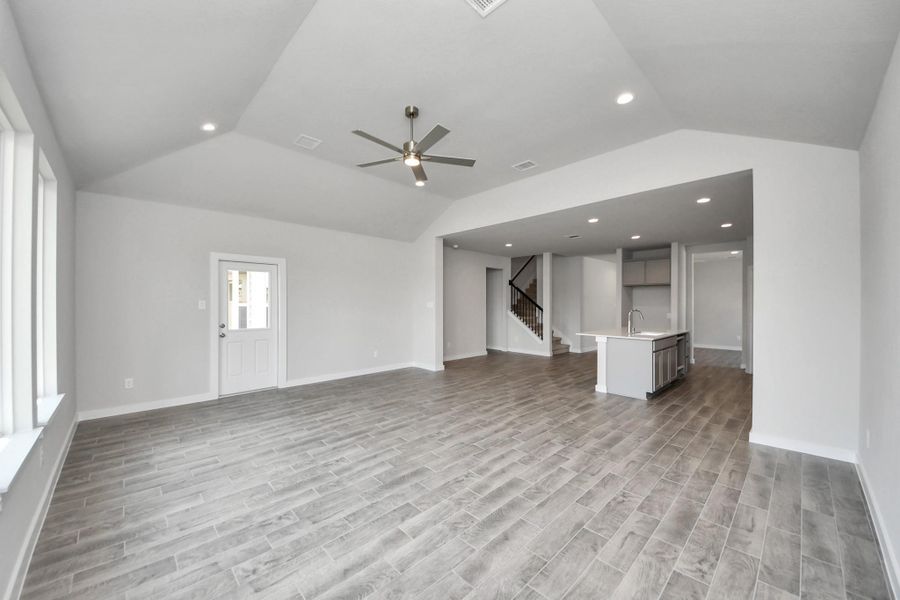 Gather the family and guests together in your lovely living room! Featuring soaring high ceilings, recessed lighting, ceiling fan, custom paint, gorgeous floors, and large windows that provide plenty of natural lighting throughout the day. Sample photo of completed home with similar floor plan. Actual colors and selections may vary.