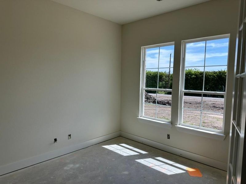 Room featuring two large grid-pattern windows, light neutral wall paint, and white baseboards