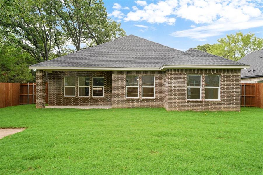 Rear exterior with brick facade and a dark shingle roof Rear exterior with brick facade and a dark shingle roof
