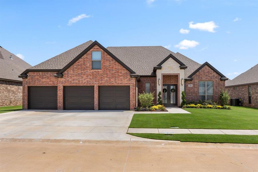 View of front of property featuring roof with shingles, a front yard, concrete driveway, and brick siding View of front of property featuring roof with shingles, a front yard, concrete driveway, and brick siding