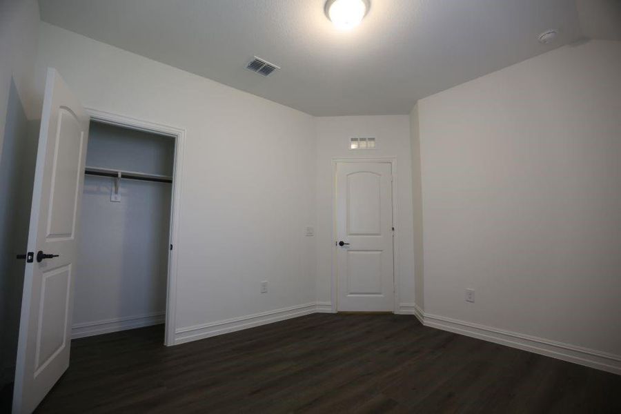 Room featuring dark wood-finish flooring, white painted walls, and white baseboards