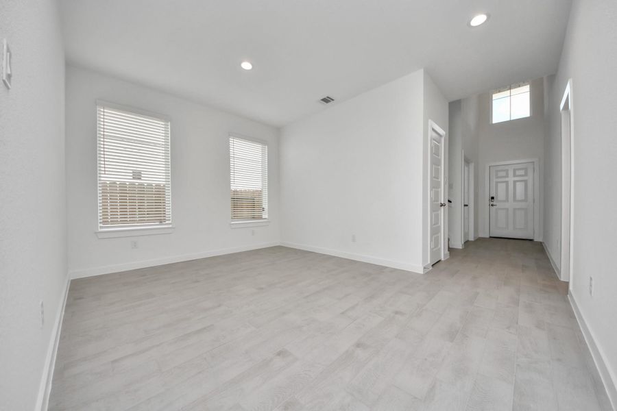 Create lasting memories with your family and friends at the dining table! This expansive dining room showcases sophisticated flooring, custom paint, and seamlessly connects to the family room and kitchen, providing an open and inviting atmosphere.