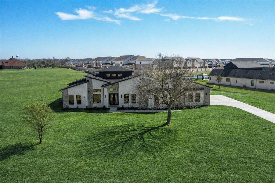 View of front facade with a front lawn, a residential view, and stone siding