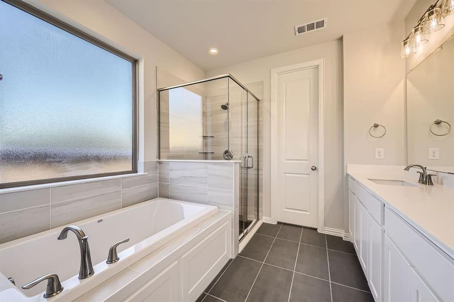 Bathroom with tile patterned floors, vanity, and independent shower and bath